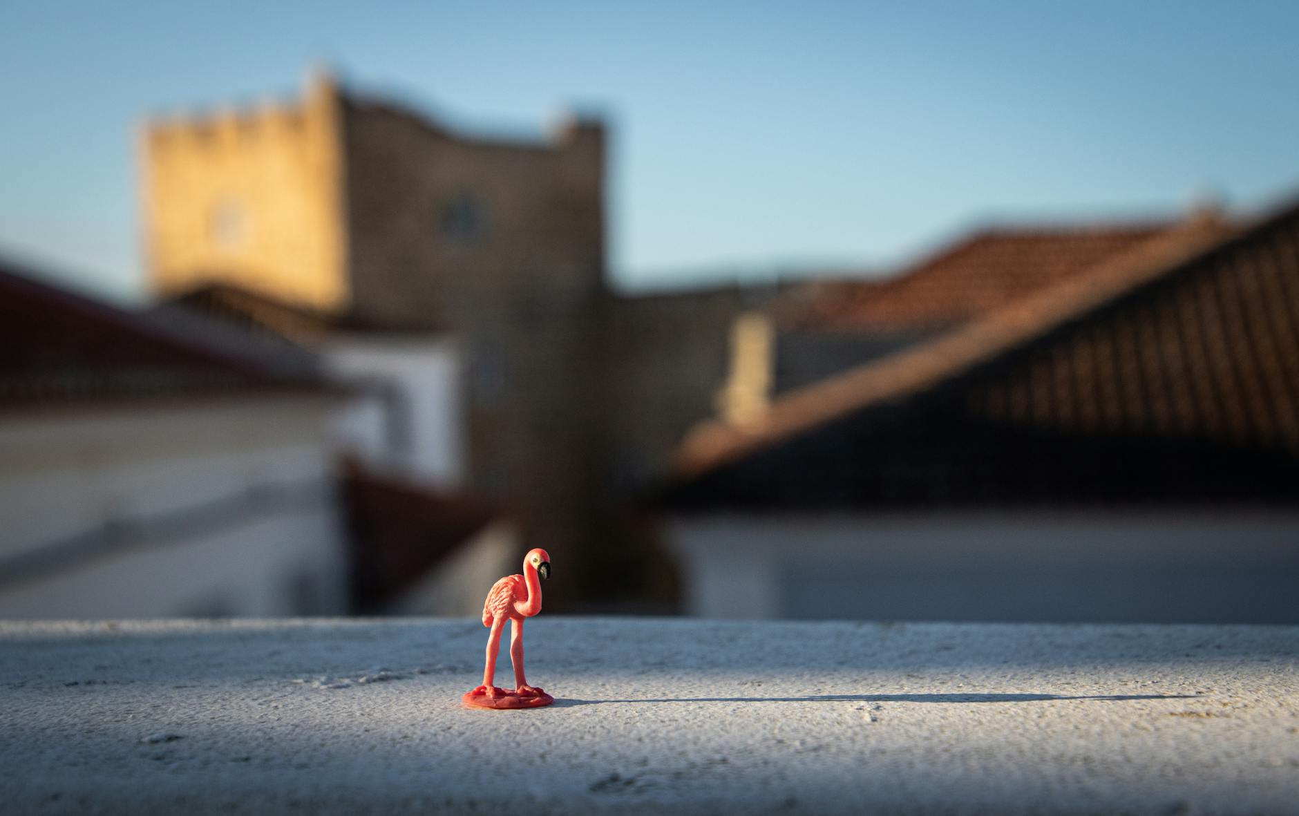 plastic flamingo toy with a castle in the background